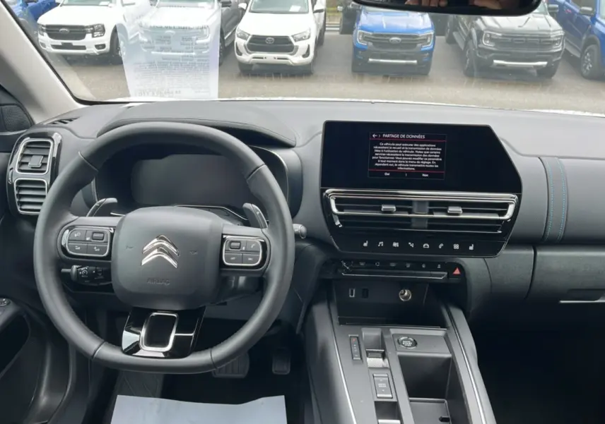 Vue intérieure du tableau de bord et volant cuir multifonctions de la Citroën C5 Aircross 2024 en noir.