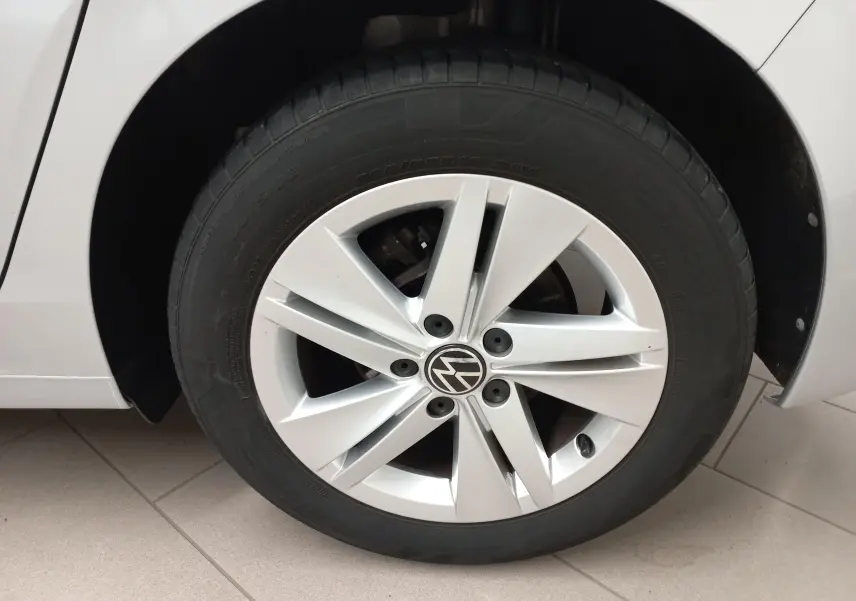 Gros plan sur la roue avant gauche d'une Volkswagen Golf 2.0 TDI 116 DSG7 Life Plus argentée, jante alliage cinq branches.
