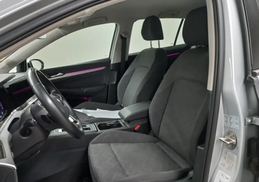 Vue intérieure côté conducteur de la Volkswagen Golf 2.0 TDI 116 DSG7 Life Plus 2023 en reflet d'argent, sièges tissu gris.