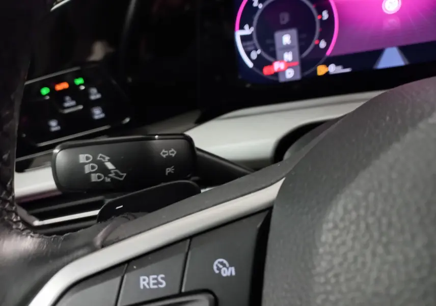 Détail du volant et des commandes au volant d'une Volkswagen Golf 2.0 TDI 116 DSG7 Life Plus 2023, intérieur noir et gris.