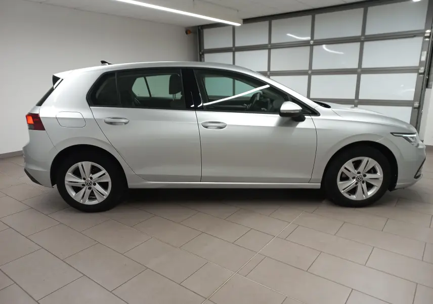 Vue latérale côté droit d'une Volkswagen Golf 2.0 TDI 116 DSG7 Life Plus 2023 en couleur reflet d'argent dans un garage.