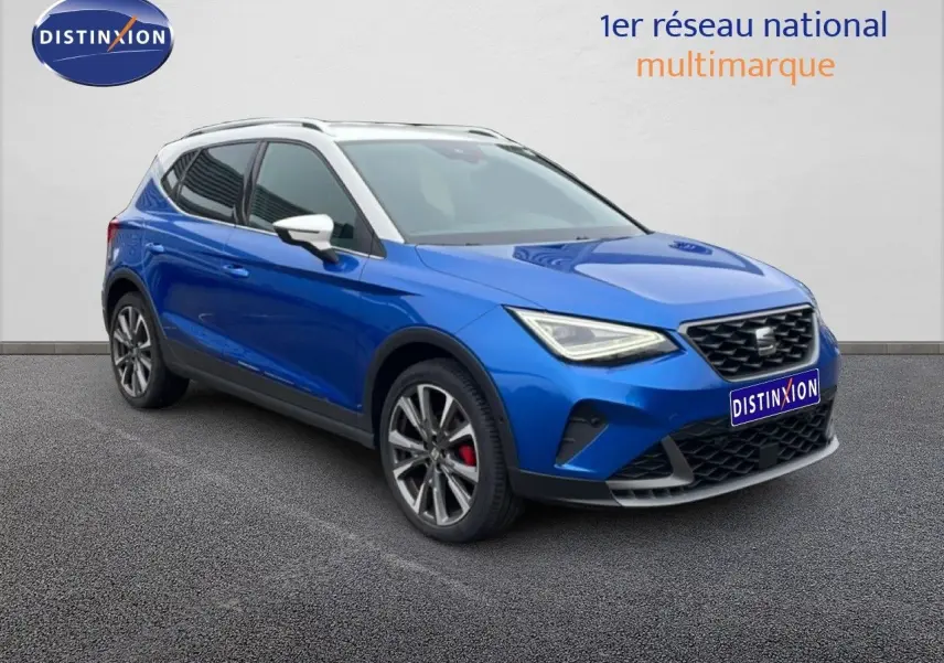 SEAT Arona 2025 bleu saphir métal avec toit blanc, vue 3/4 avant mettant en valeur les jantes et calandre.