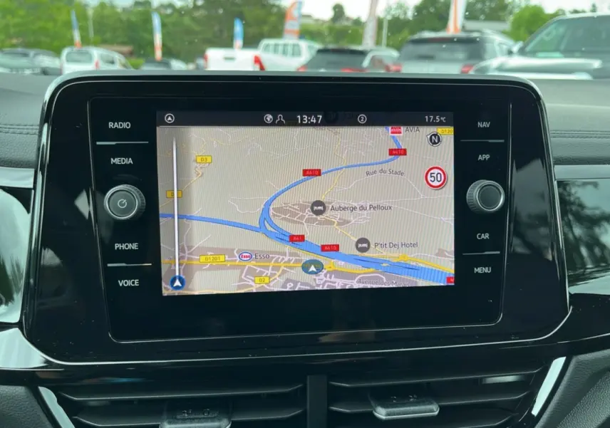 Écran tactile central du Volkswagen T-Roc 2025 affichant la navigation GPS avec commandes autour de l'écran noir brillant.