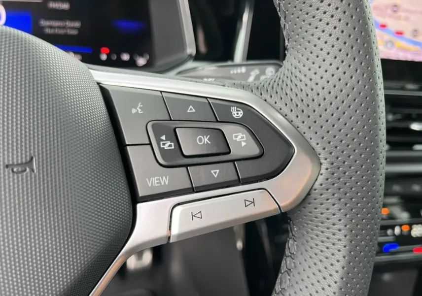 Gros plan sur le volant cuir perforé du Volkswagen T-Roc TDI 150 R-Line Black avec commandes multifonctions.