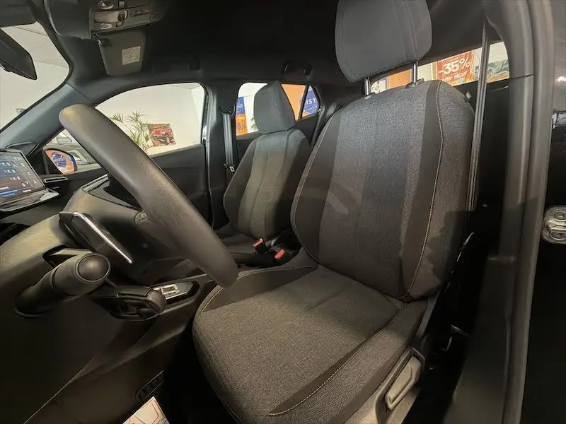 Vue intérieure côté conducteur du Peugeot 2008 Hybrid 145ch Style 2025, sièges tissu gris et tableau de bord noir.