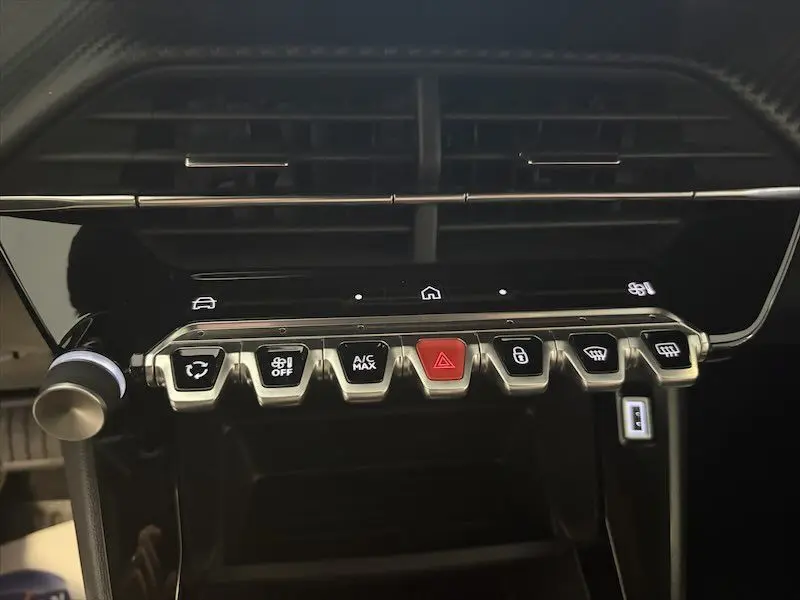 Vue rapprochée de la console centrale noire du Peugeot 2008 Hybrid 145ch avec boutons de commande et écran tactile.