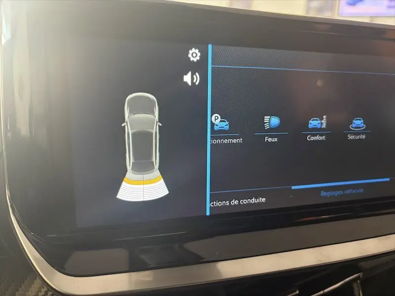 Écran tactile intérieur du Peugeot 2008 Hybrid 145ch Style montrant l'alerte de proximité arrière avec interface de réglages.