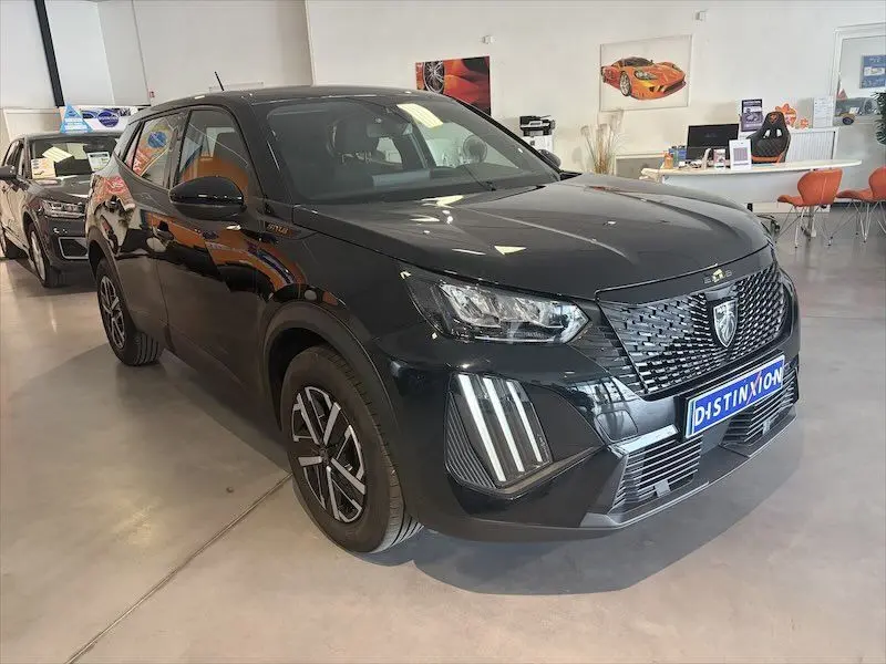 Peugeot 2008 Hybrid noir métal en 3/4 avant droit, avec calandre distinctive et feux LED verticaux showroom.