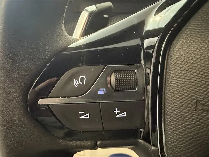 Gros plan sur les commandes noires du volant côté gauche du Peugeot 2008 Hybrid 145ch Style 2025.