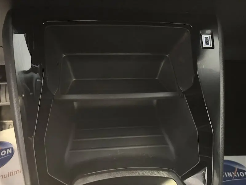Gros plan sur le rangement central noir mat avec port USB du Peugeot 2008 Hybrid 145ch Style 2025.