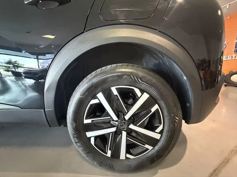 Gros plan sur la roue arrière droite d’un Peugeot 2008 noir métal, mettant en valeur la jante noire et argentée au design moderne.