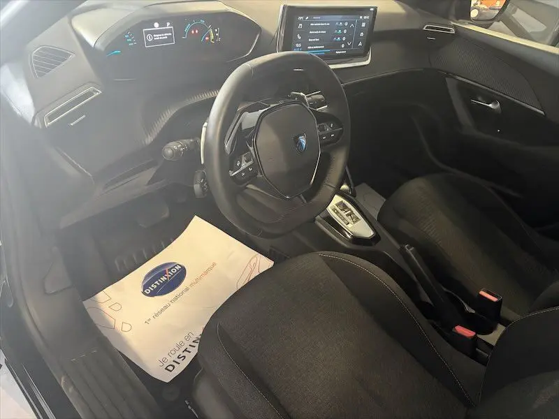 Vue intérieure côté conducteur du Peugeot 2008 Hybrid 145ch noir métal, avec tableau de bord digital et écran tactile central.