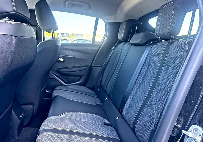 Vue latérale droite de la banquette arrière en tissu gris et noir de la Peugeot 208 1.2 100 Allure noire, 2025.