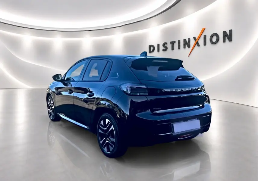 Peugeot 208 noire vue en 3/4 arrière droit dans un showroom lumineux avec jantes alu et vitres teintées.