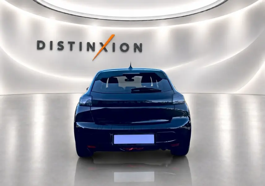 Vue arrière d'une Peugeot 208 noire 1.2 100 Allure 2025, avec feux arrière LED et lunette teintée dans un showroom.