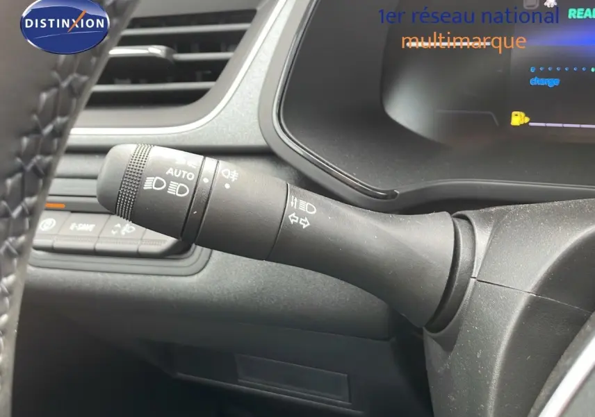 Gros plan sur la commande des feux et clignotants à gauche du volant dans l'habitacle du Renault Captur gris cassiopée.