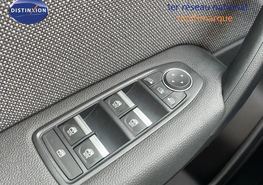 Gros plan sur les commandes des vitres électriques côté conducteur d'une Renault Captur 2025, finition tissu gris.