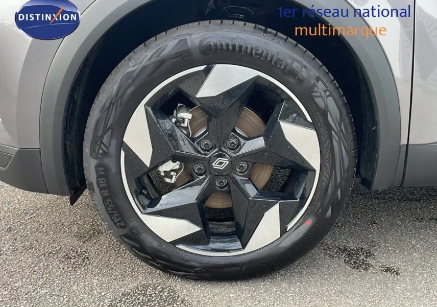 Gros plan sur la roue avant droite du Renault Captur gris Cassiopée métal avec jante noire et argentée en étoile.