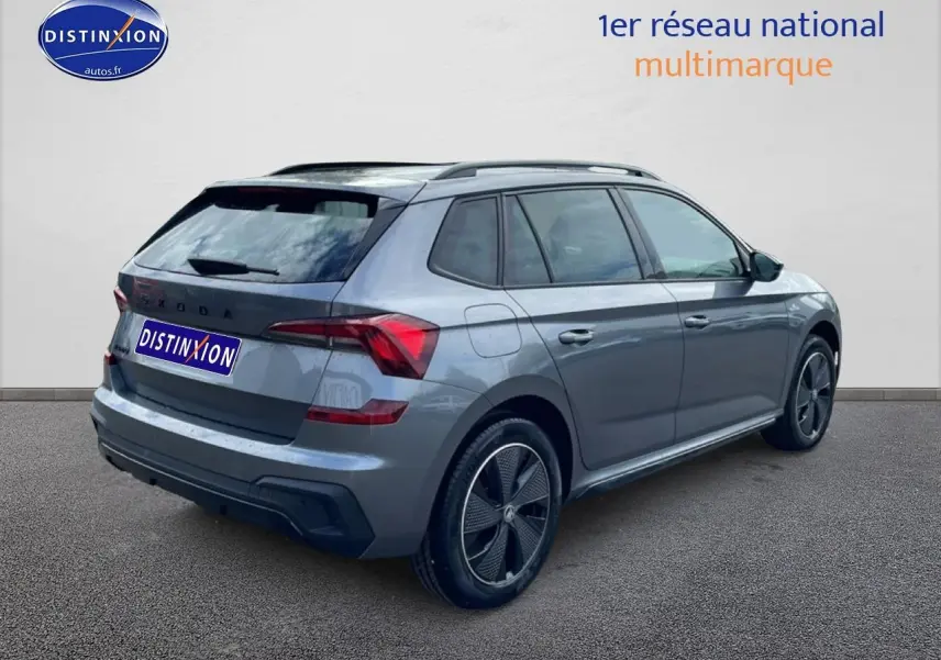 Vue 3/4 arrière droite d’un Skoda Kamiq gris graphite avec jantes alu noires et toit panoramique en verre.