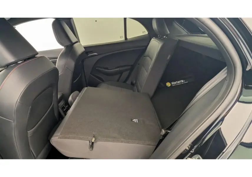 Vue intérieure arrière droite du MG3 1.5 Hybrid+ 195 Luxury, montrant la banquette rabattue et la sellerie tissu/similicuir noir.