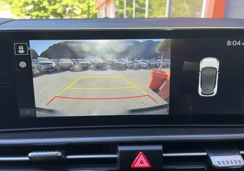 Affichage caméra de recul avec vue arrière sur parking, tableau de bord du Kia Sportage gris céramique toit noir.