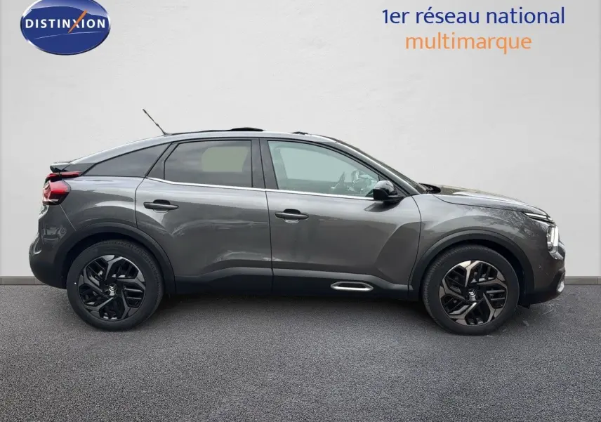 Profil côté gauche d'une Citroën C4 2021 gris avec toit noir et jantes noires bicolores, toit ouvrant visible.