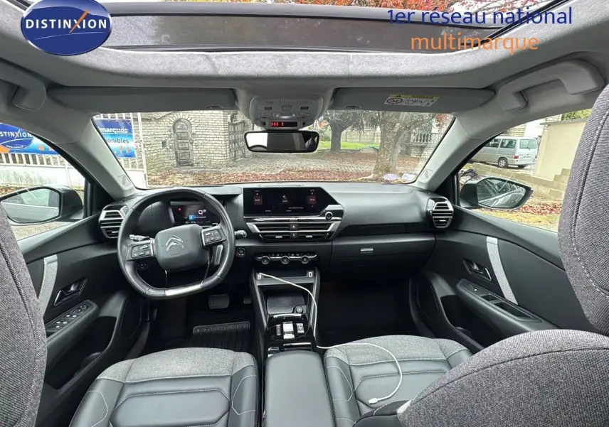 Intérieur moderne de la Citroën C4 PureTech 130ch, vue avant avec toit ouvrant et sellerie grise élégante.