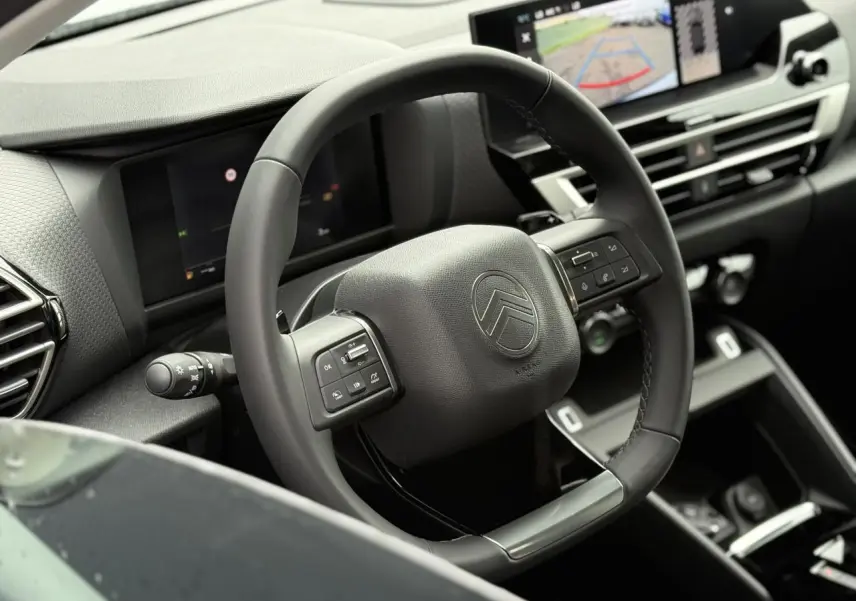 Volant cuir noir de Citroën C4 NV Hybrid 2025 avec commandes intégrées et écran tactile affichant la caméra de recul