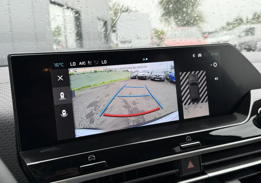 Écran tactile intérieur affichant la caméra de recul et l'aide au stationnement du Citroën C4 blanc Okénite avec toit noir.