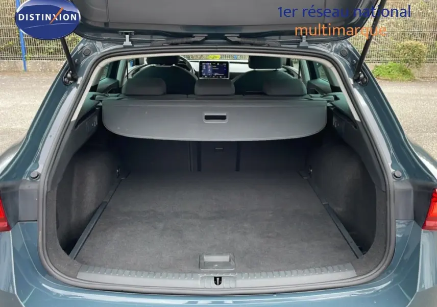 Coffre ouvert vu de l'arrière d'une SEAT LEON ST gris magnétique, montrant un espace de chargement spacieux.