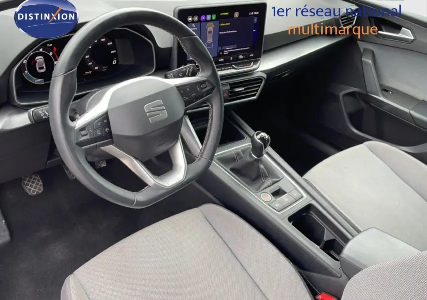 Vue intérieure côté conducteur du SEAT LEON ST 2025 gris, volant cuir multifonction et boîte manuelle visible.