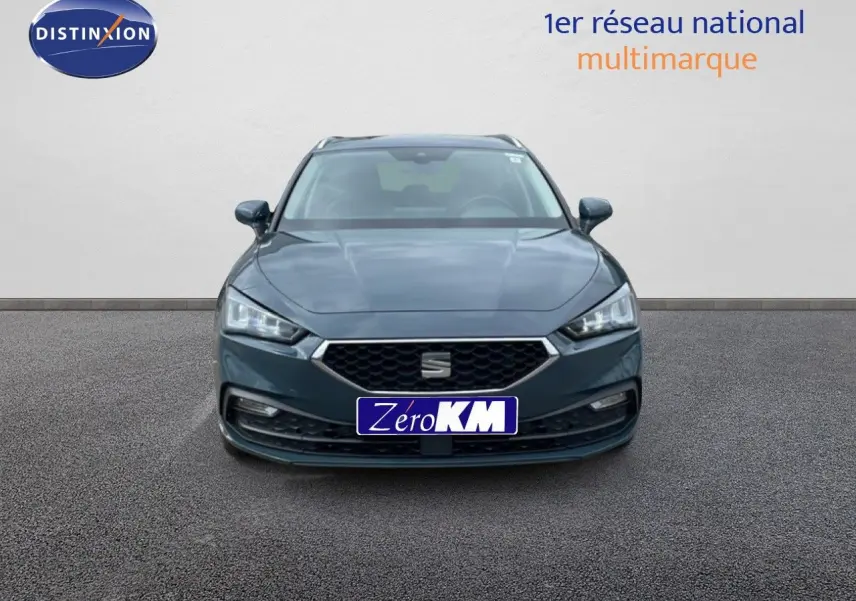 Vue frontale d'une SEAT LEON ST 2.0 TDI 115CH STYLE XL en gris magnétique métal, avec calandre hexagonale et phares LED.