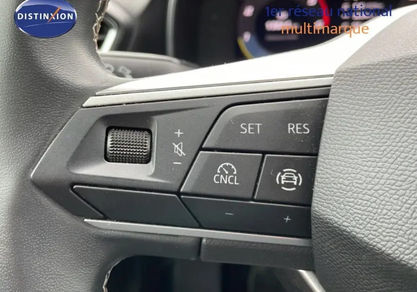 Gros plan sur les commandes de régulateur de vitesse au volant d’une SEAT LEON ST gris magnétique 2025.