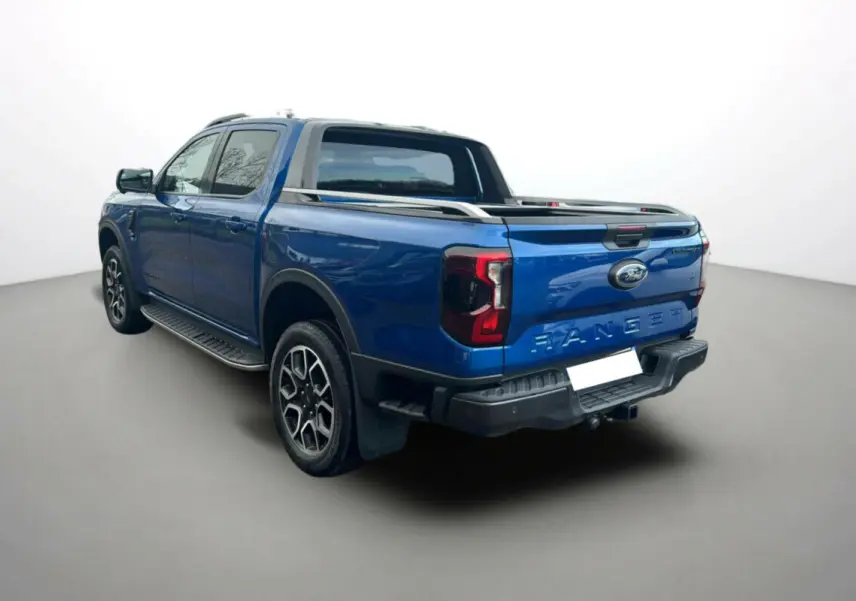 Ford Ranger 2.0 205 Wildtrak Plus bleu lightning vu en 3/4 arrière droit avec arceau sport et barres de toit.