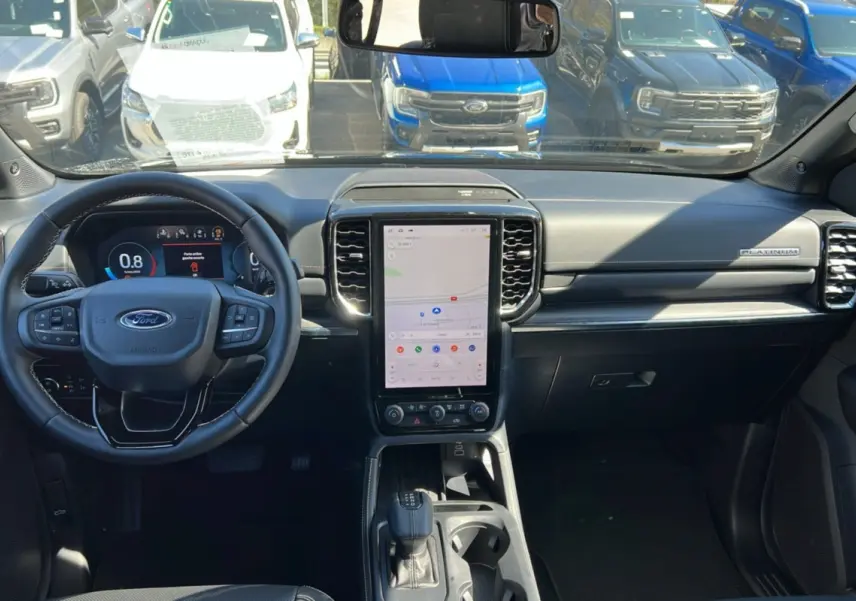 Vue intérieure avant du Ford Ranger 2026 noir agate, avec grand écran central vertical et volant multifonctions cuir.