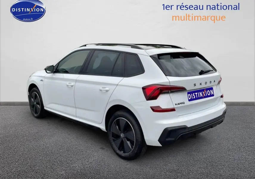 Vue 3/4 arrière droite d'un Skoda Kamiq blanc nacré avec jantes noires et toit panoramique en verre.