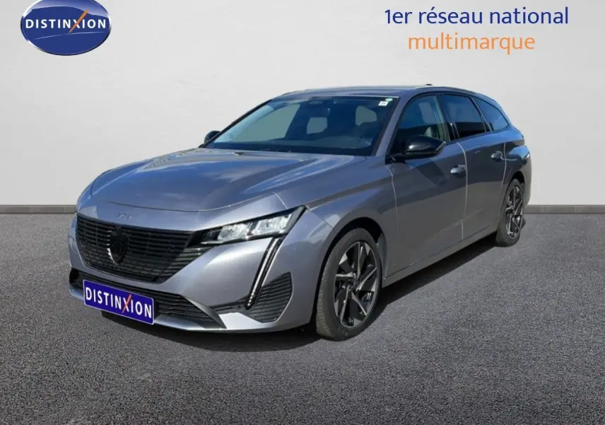Peugeot 308 SW gris Artense métal vue 3/4 avant droit, avec calandre noire distinctive et jantes bi-ton.