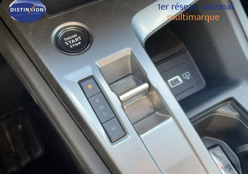 Vue rapprochée de la console centrale de la Peugeot 308 SW Hybrid avec bouton start/stop et levier de boîte automatique.