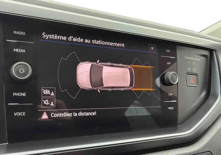 Écran central du système d'aide au stationnement de la Volkswagen Polo Business, affichant une vue aérienne du véhicule blanc.