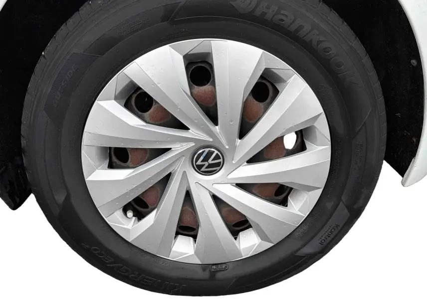 Gros plan sur la roue avant droite d'une Volkswagen Polo Business blanche avec enjoliveur argenté et pneu Hankook.