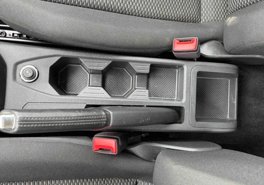 Vue plongeante sur la console centrale noire avec frein à main et prises 12V de la Volkswagen Polo Business 2021.
