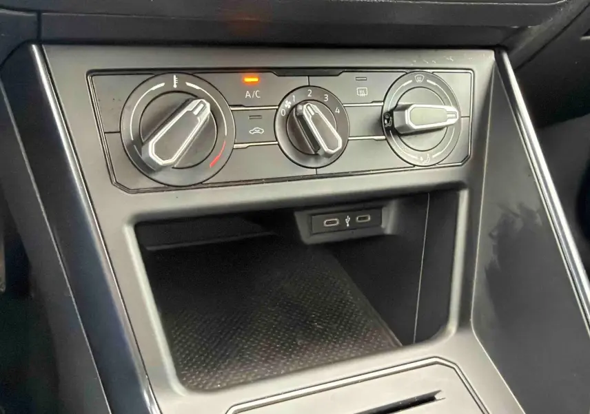 Vue rapprochée de la console centrale de la Volkswagen Polo Business 2021, montrant les commandes de climatisation manuelle et ports USB.