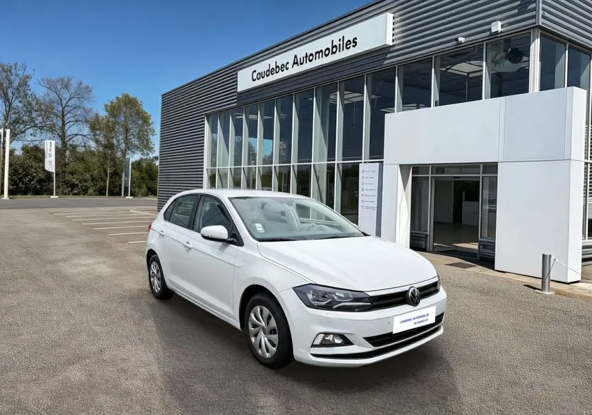 Volkswagen Polo Business blanche vue en 3/4 avant droit devant un bâtiment de concession.