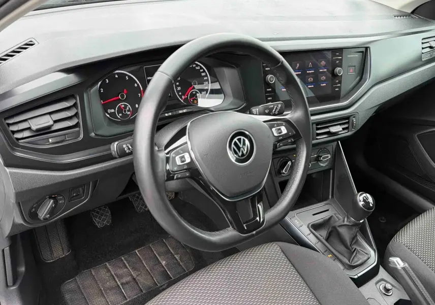 Vue intérieure côté conducteur du tableau de bord et volant noir de la Volkswagen Polo Business 2021 avec boîte manuelle.
