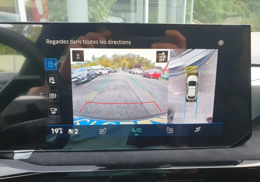 Écran de caméra de recul et vue 360° dans une Renault Clio VI noire étoile, affichage intérieur moderne.
