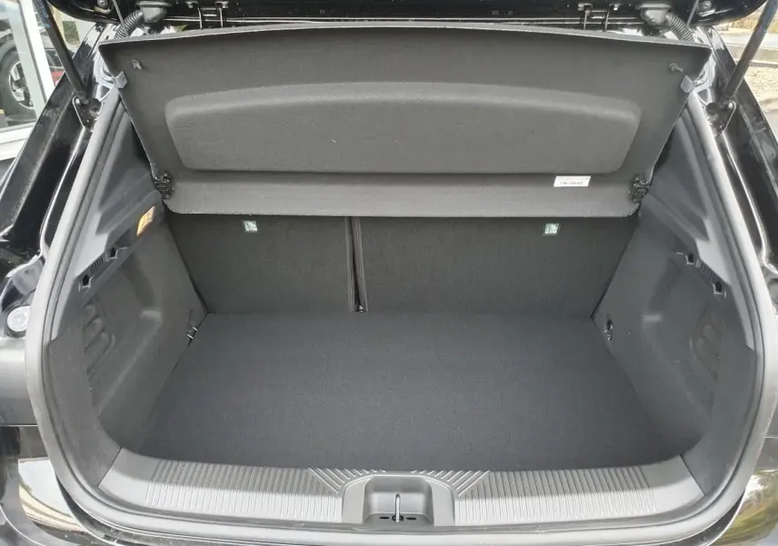 Coffre ouvert vu de l’arrière d’une Renault Clio VI noire étoile, montrant un espace de chargement vide et propre.