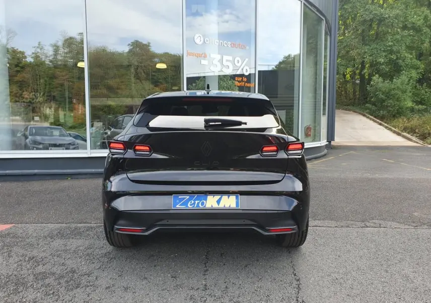 Vue arrière d'une Renault Clio VI noire étoile, avec feux LED distinctifs et vitres arrière surteintées.
