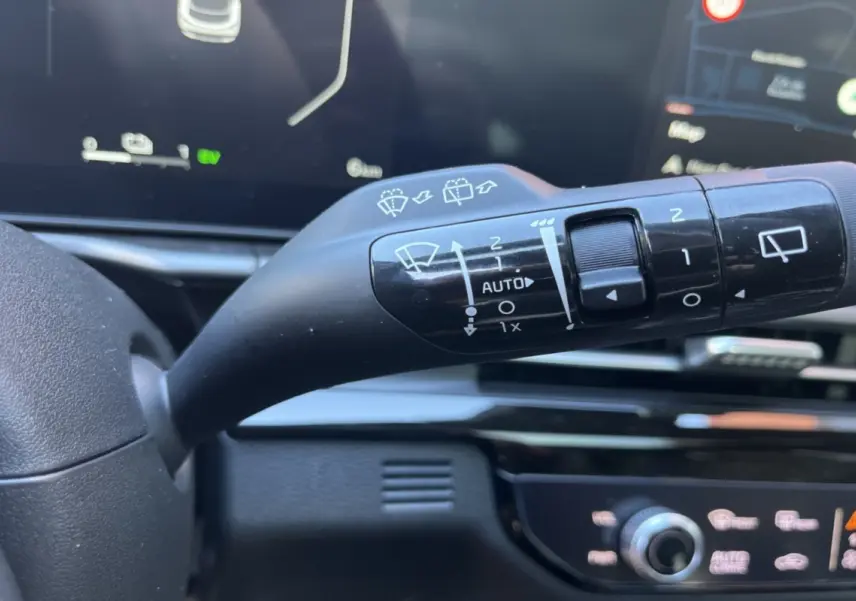Gros plan sur la commande d’essuie-glace à gauche du volant dans l’habitacle du Kia Sportage gris céramique 2026.
