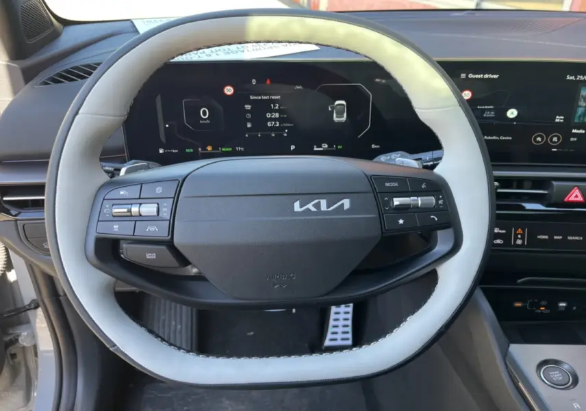 Vue rapprochée du volant cuir clair du Kia Sportage 2026 avec tableau de bord digital et écran tactile noir.