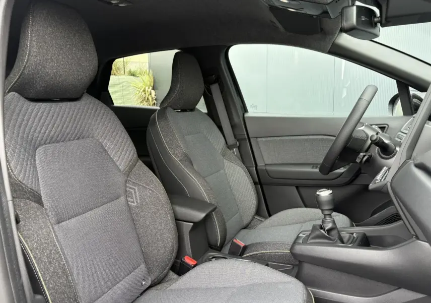 Vue intérieure côté gauche du Renault Captur 2025 Eco-G 100 Techno, sièges gris texturés et volant multifonction.